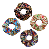 Four Japanese fabric hair scrunchies with different colorful floral and patterned prints.